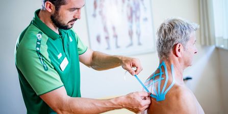 Therapeut behandelt Patientin mit Theraband