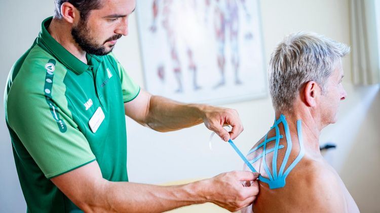 Therapeut behandelt Patientin mit Theraband