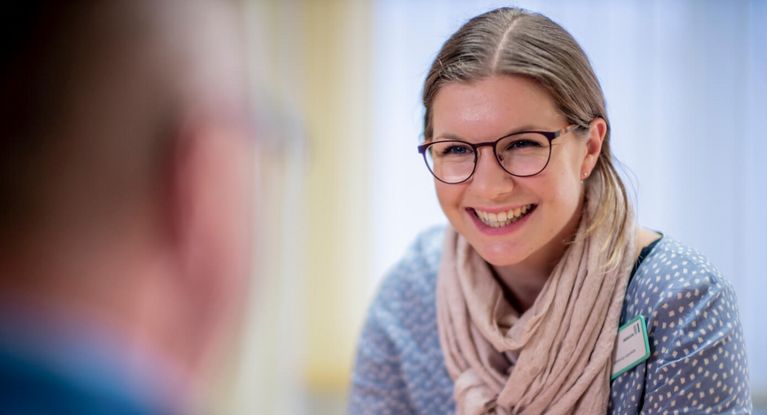 Freundliche Sozialarbeiterin spricht mit Patienten