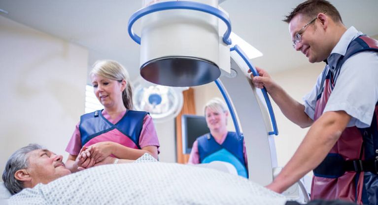 Krankenpfleger und Arzt bereiten den Patienten für eine urologische Röntgenaufnahme vor