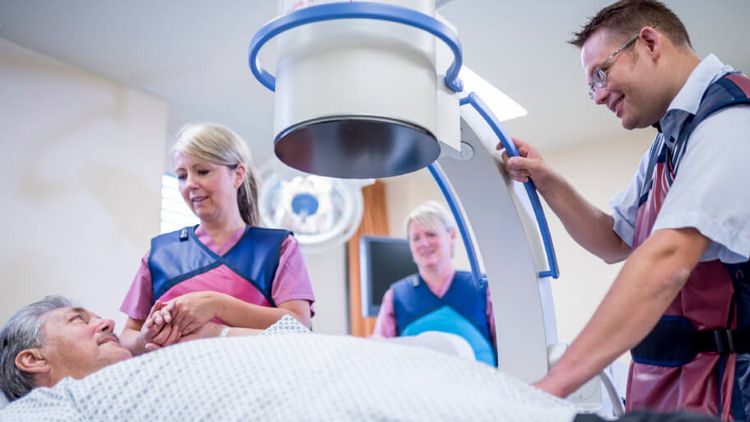 Krankenpfleger und Arzt bereiten den Patienten für eine urologische Röntgenaufnahme vor