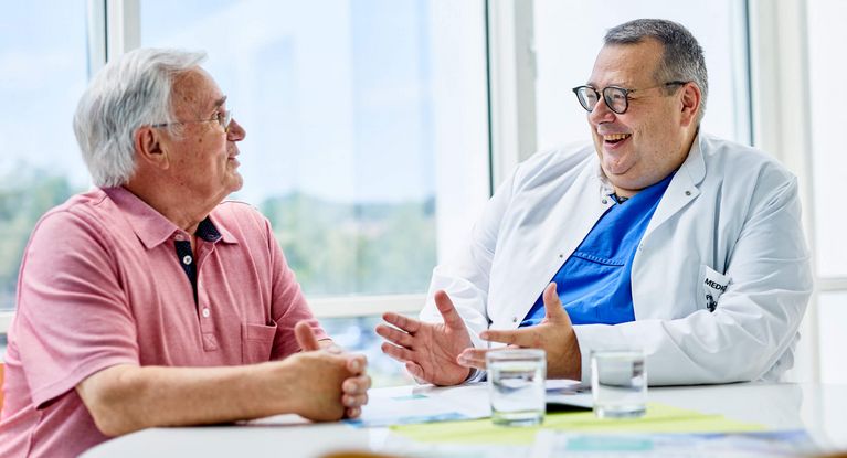 Arzt spricht mit glücklichem Patienten