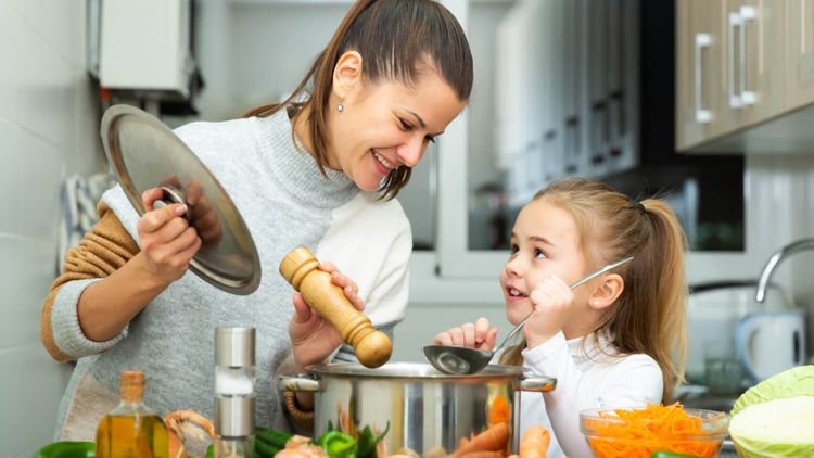 Weibliche Person beim Kochen mit einem Kind