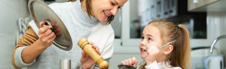 Weibliche Person beim Kochen mit einem Kind