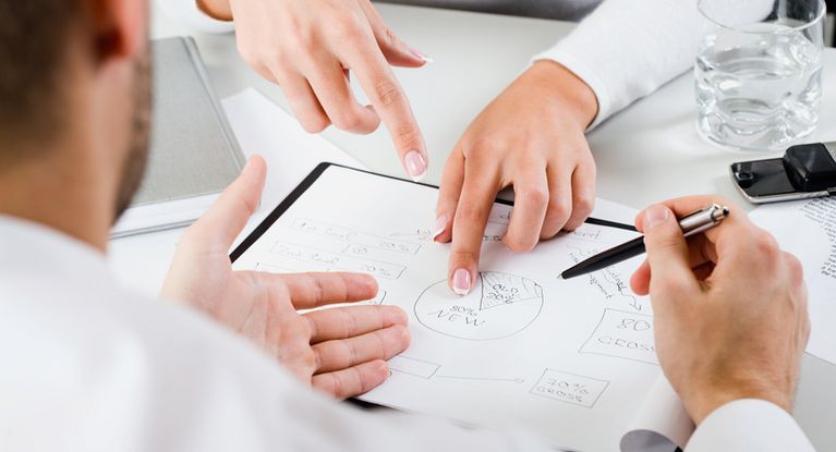 Ein Team junger Führungskräfte diskutiert über ein Kuchendiagramm