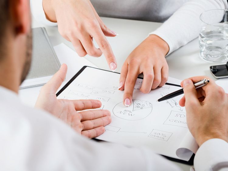 Ein Team junger Führungskräfte diskutiert über ein Kuchendiagramm