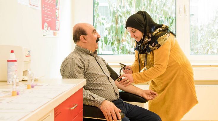 Pflegekraft misst Blutdruck eines Patienten