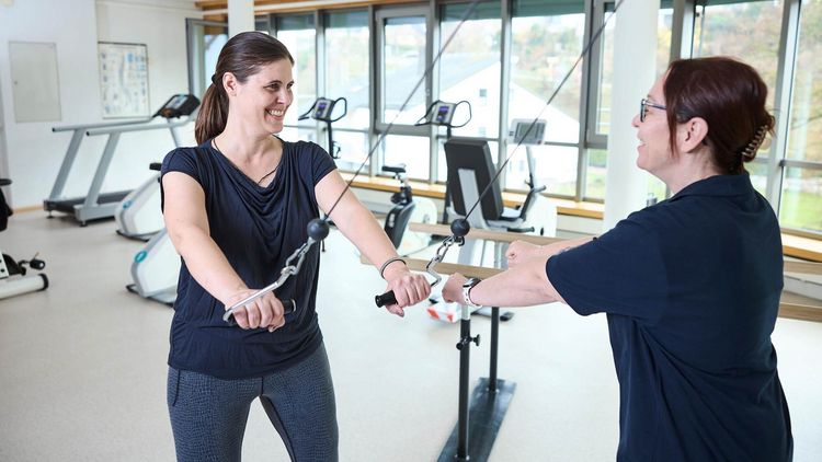 Patientin mit Therapeutin bei der Bewegungstherapie