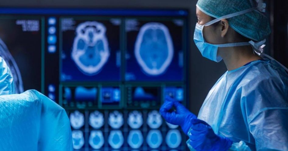 Ärzte begutachten während einer OP Röntgenbilder des Schädels am Bildschirm