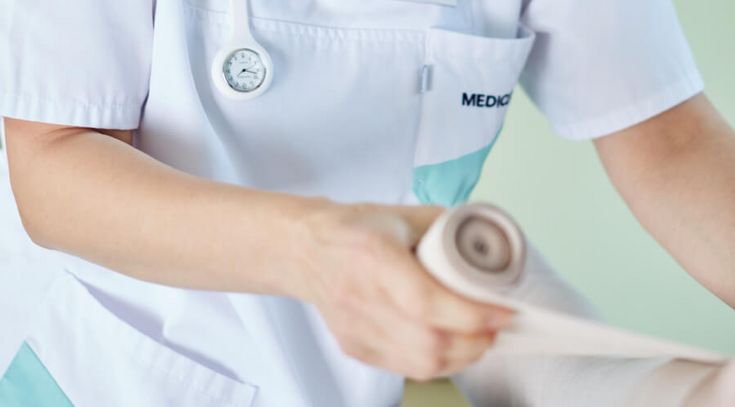 Pflegekraft verbindet Fuß