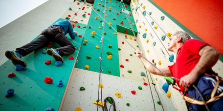 Sporttherapeuten klettern an der Kletterwand