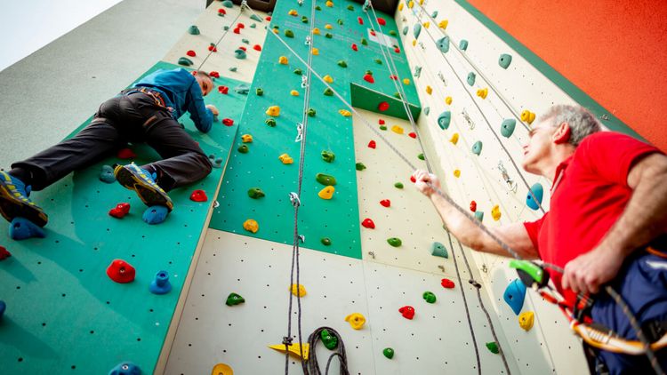 Sporttherapeuten klettern an der Kletterwand