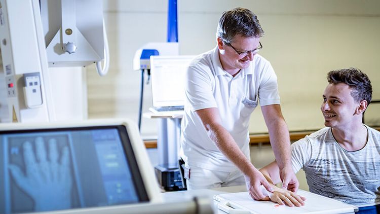 Arzt röngt die Hand eines Patienten