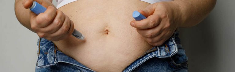 Übergewichtige Patientin spritzt sich mit einem Pen in den Bauch