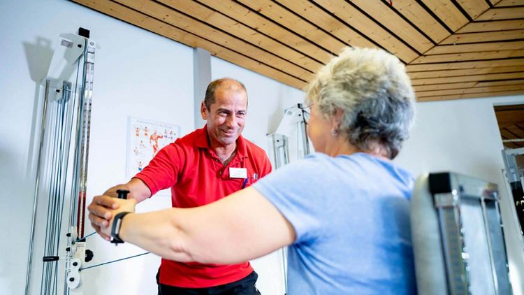 Patientin mit Therapeut beim Gerätetraining