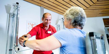 Patientin mit Therapeut beim Gerätetraining