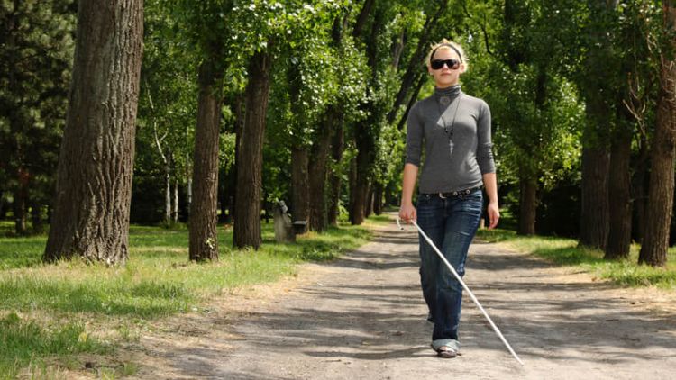 Blinde Frau läuft in der Natur spazieren