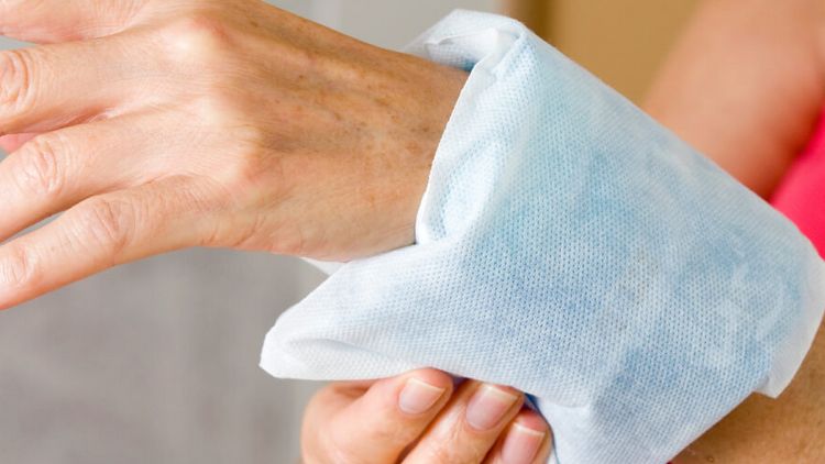 Person hält sich ein Kühlpad ums Handgelenk
