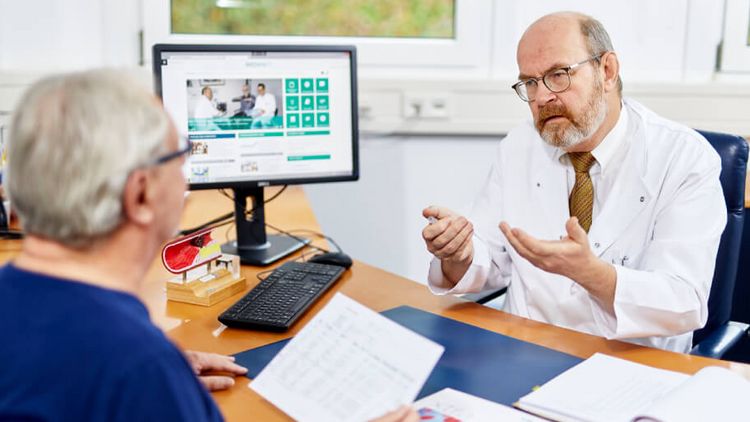 Arzt klärt Patientin über kardiologische Reha auf