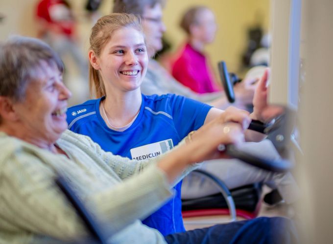 Therapeutin unterstützen Patientin beim Kardiotraining