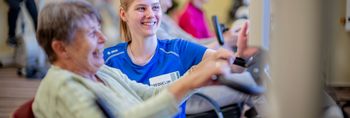 Therapeutin unterstützen Patientin beim Kardiotraining
