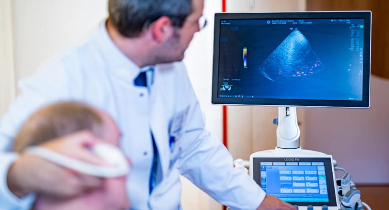 Arzt untersucht den Kopf eines Patienten mit Ultraschall