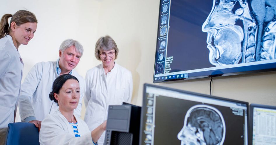 Ärztliches Team sieht sich CT-Scan an in neurologischer Reha