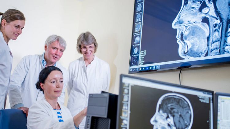 Ärztliches Team sieht sich CT-Scan an in neurologischer Reha