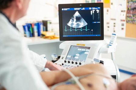 Arzt führt bei einem Patienten eine Herzuntersuchung per Ultraschall durch. 
