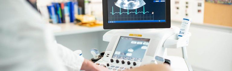 Arzt führt bei einem Patienten eine Herzuntersuchung per Ultraschall durch. 