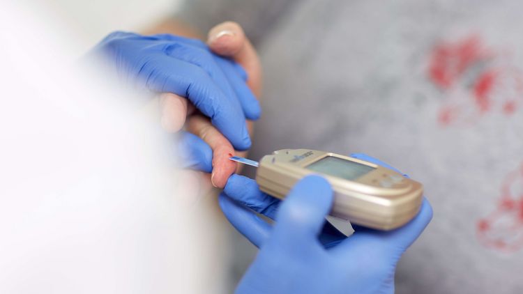 Arzt testet Blutzucker einer Patientin