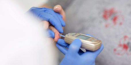 Arzt testet Blutzucker einer Patientin