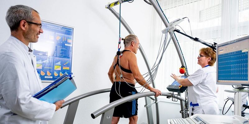 Männliche Person beim Belastungs-EKG, Pflegekraft und Arzt