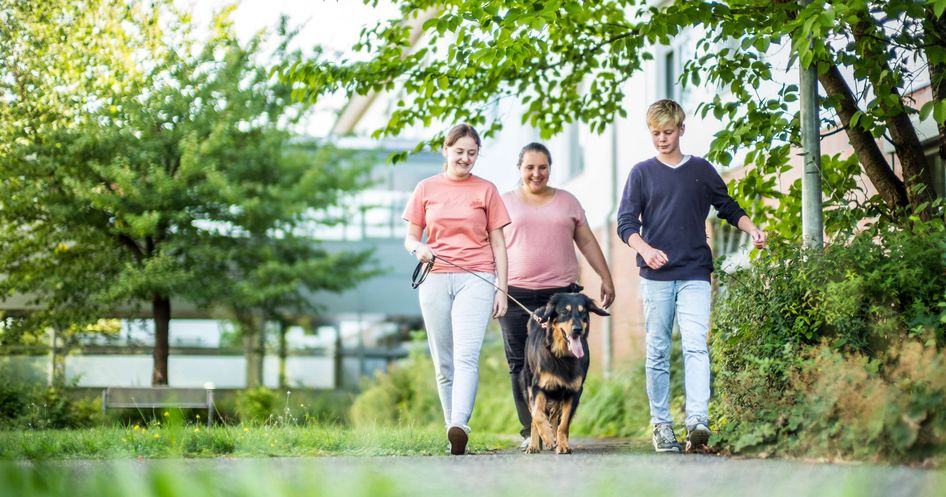 Patienten und Therapeitin mit dem Therapiehund unterwegs