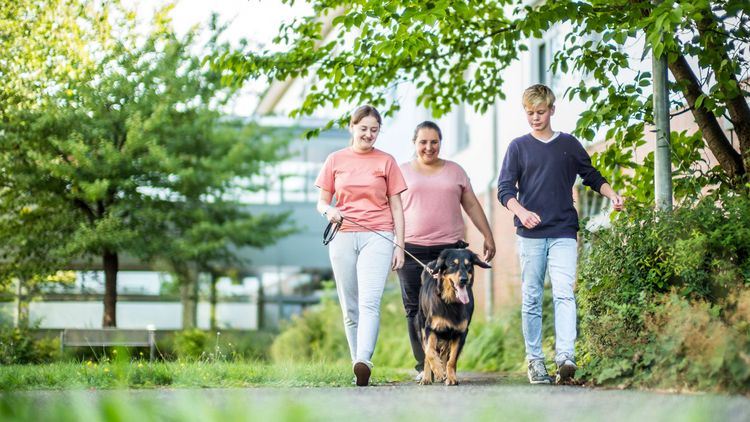 Patienten und Therapeitin mit dem Therapiehund unterwegs