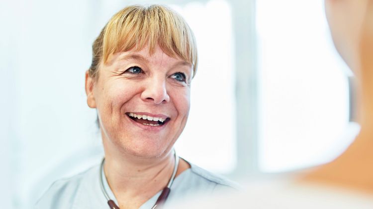 Krankenpflegerin lacht im Gespräch