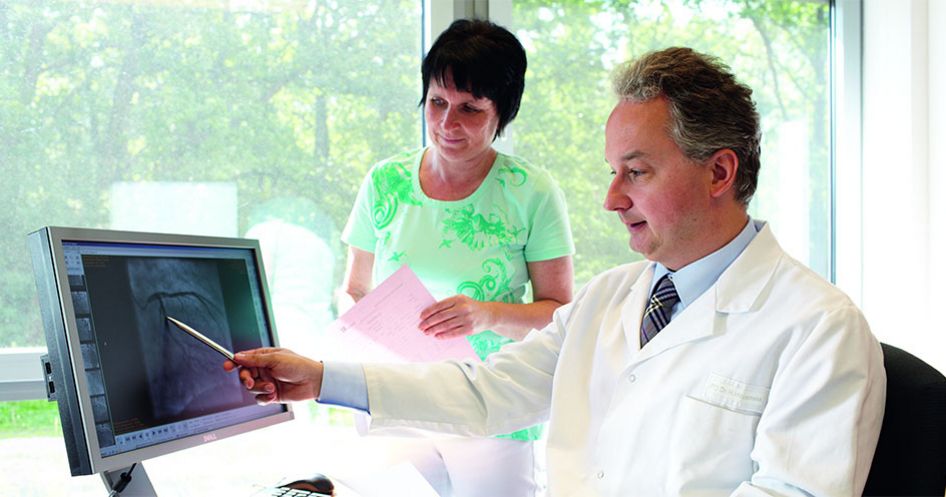 Arzt zeigt Gefäße auf dem Bildschirm