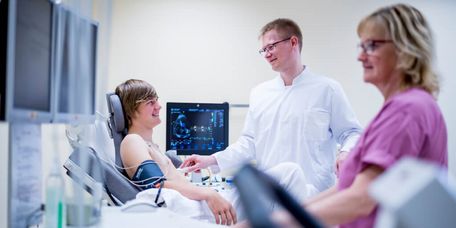 Arzt untersucht jungen Patienten mit Ultraschall