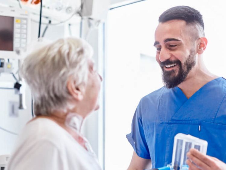Lächende Pflegekraft im Akuthaus spricht mit Patientin
