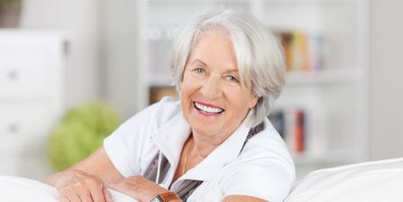 lächelnde Senioren lehnt sich über Sofalehne