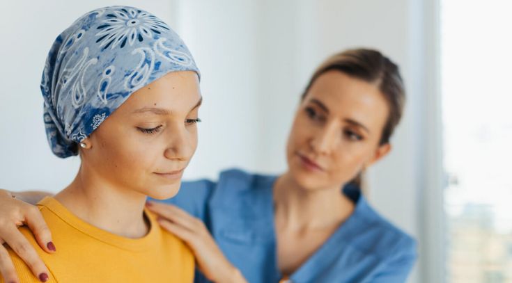 Jugendliches krebskrankes Mädchen mit Pflegekraft, die es tröstet