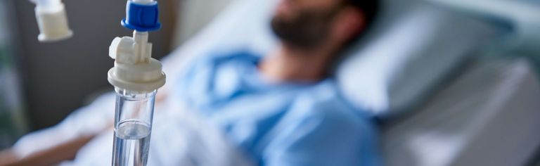 Patient liegt im Krankenhausbett und erhält eine Infusion