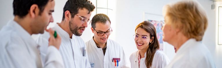 Ärztinnen und Ärzte besprechen gemeinsam einen Tabelle