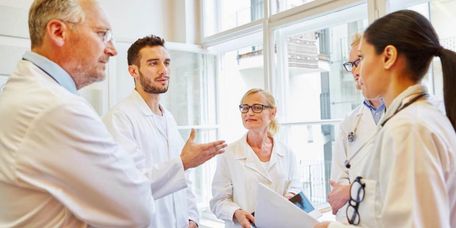 Ärzteteam Ein Team aus unterschiedlich erfahrenen Ärztinnen und Ärzten diskutiert miteinander