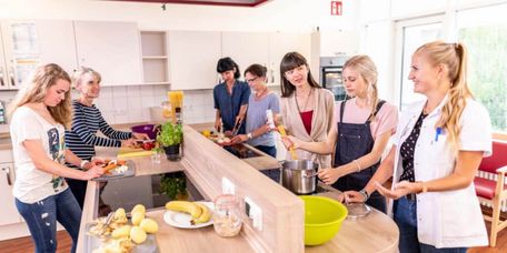 Patientinnen mit Therapeutin in der Lehrküche einer Rehaklinik bei der Ernährungstherapie