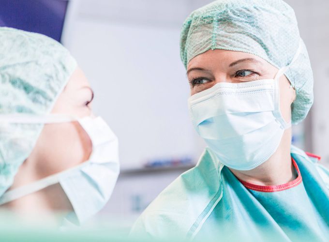 Zwei Ärztinnen mit Mundschutz verstehen sich ohne Worte im OP