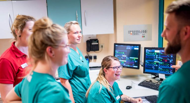 Krankenpflegerinnen und Pfleger besprechen die Schichtübergabe