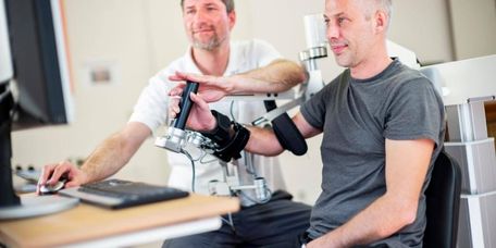 Patient bei der Armtherapie mit einer Robotik