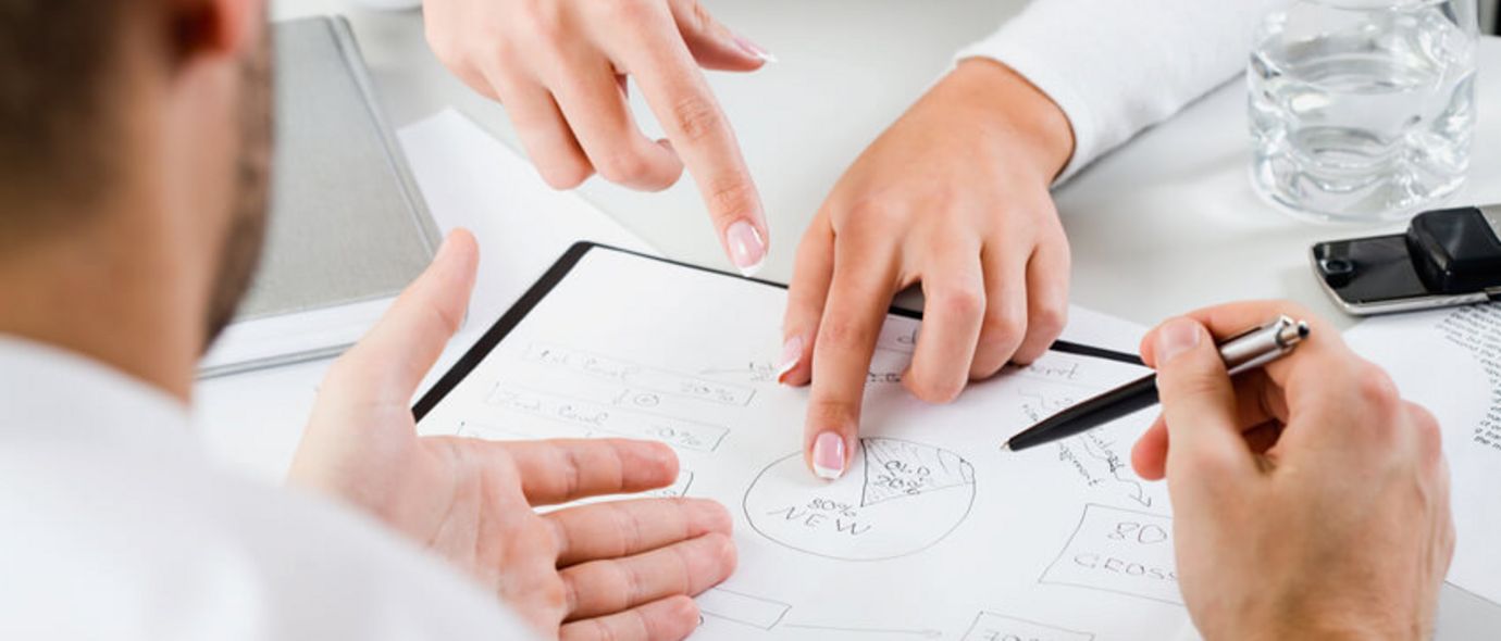 Ein Team junger Führungskräfte diskutiert über ein Kuchendiagramm