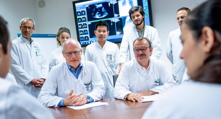 Eine Gruppe verschieden alter Ärzte hält eine Konferenz ab